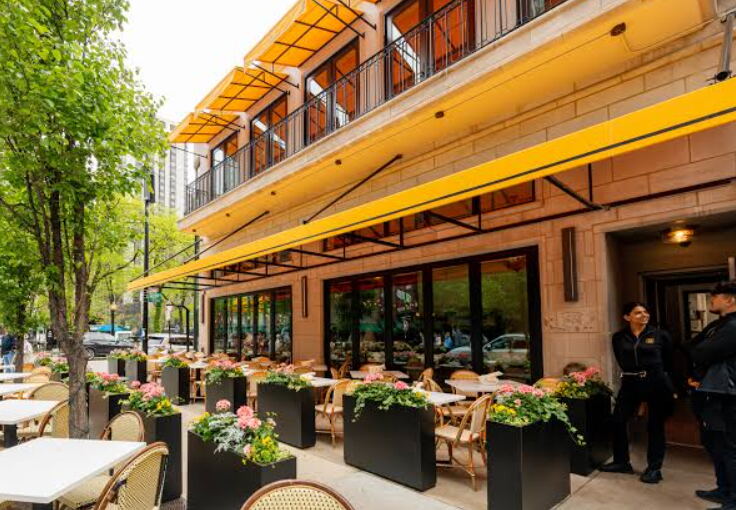 Bellevue restaurant patio with yellow awnings, planters and outdoor tables