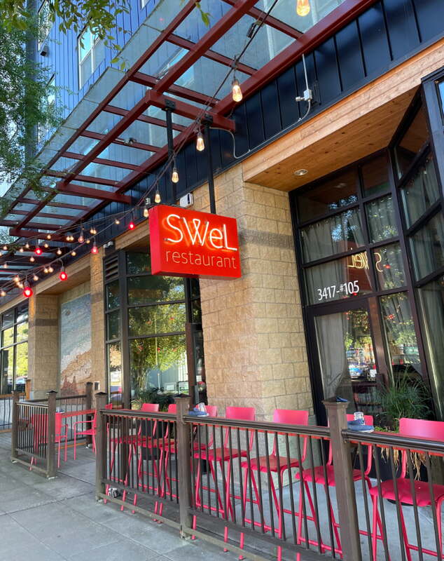 Seattle restaurant patio with red railings and a clean concrete sidewalk