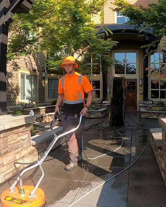 Deep Water technician surface cleaning the entry courtyard of an apartment community