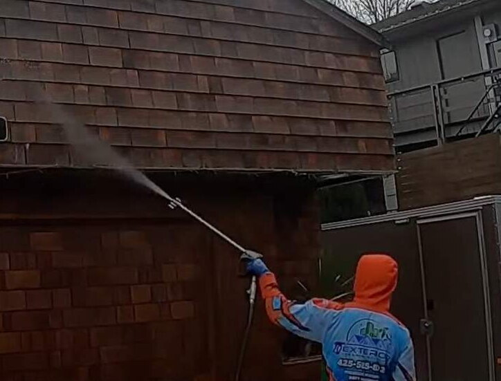 Deep Water technician soft washing the cedar siding of a Bellevue home