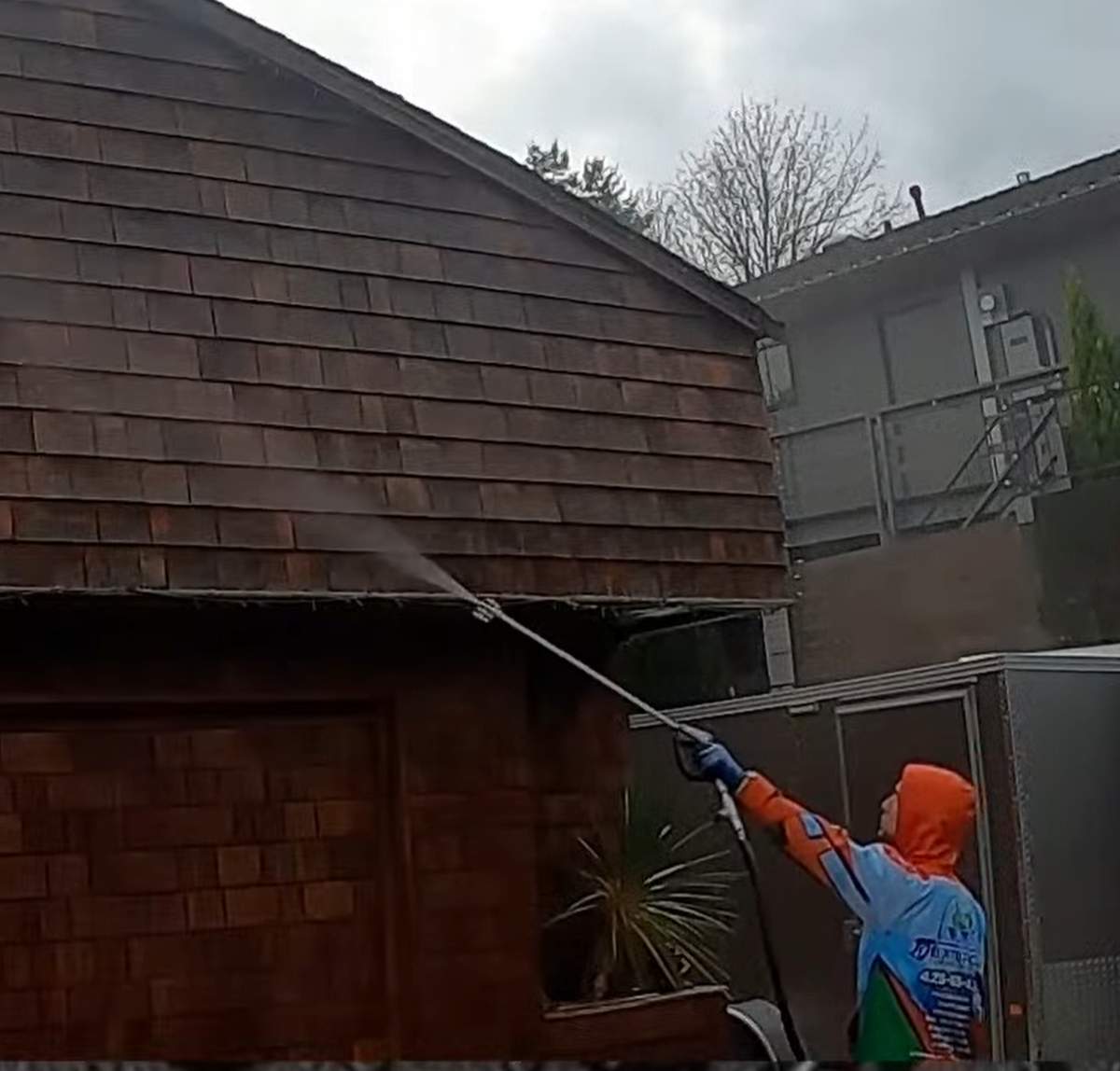 Deep Water technician soft washing cedar shingle siding in Ballard
