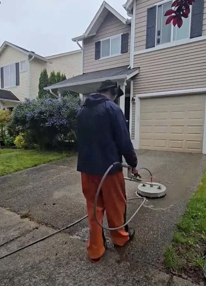 Deep Water technician surface cleaning a driveway at a Seattle-area home