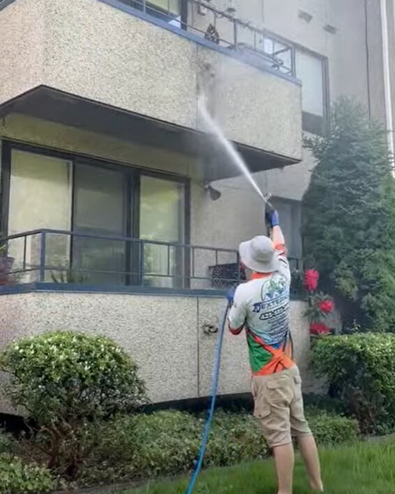 Deep Water technician soft washing the balconies of a three-story condominium building