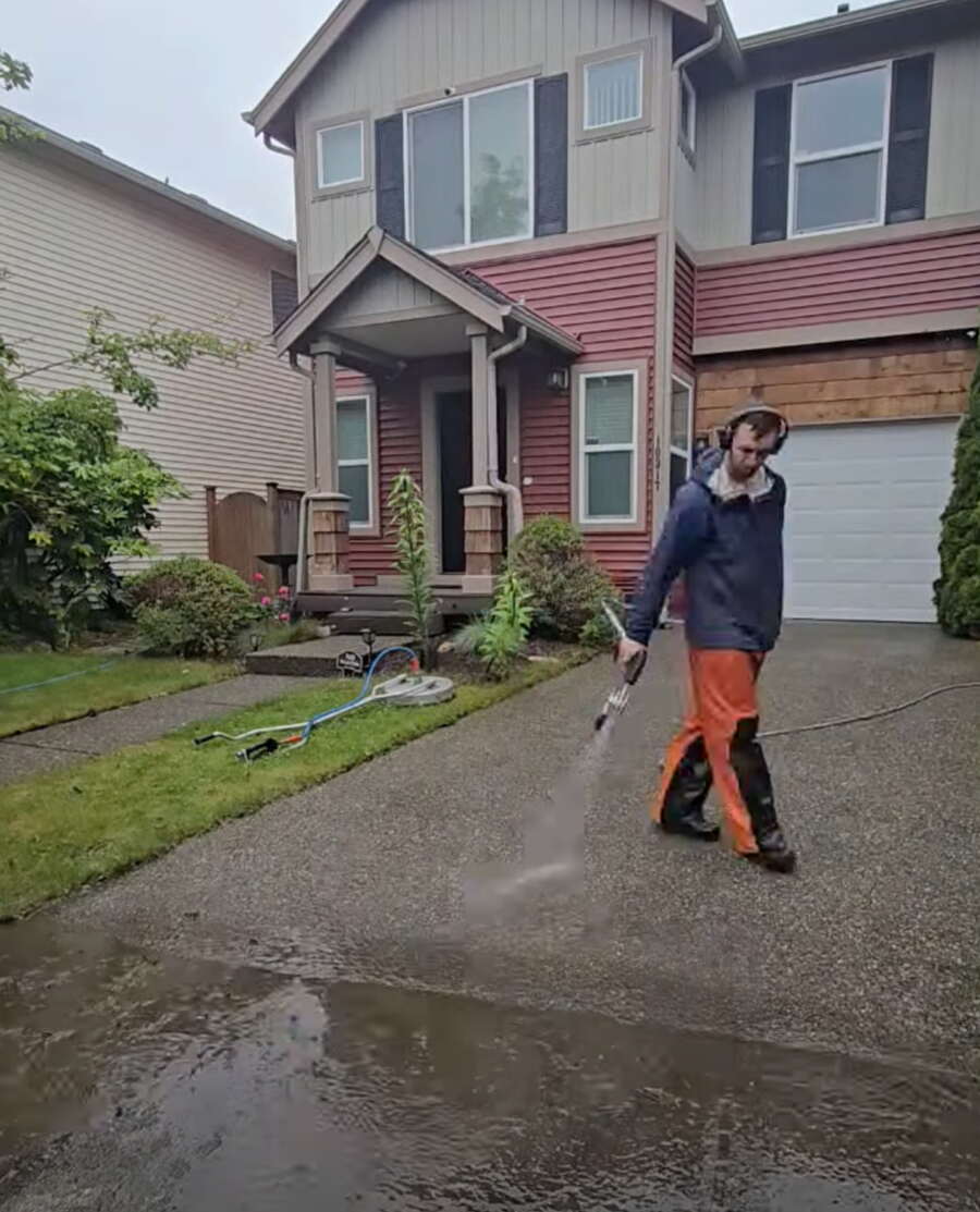 Deep Water technician pressure washing the driveway of a Bellevue home