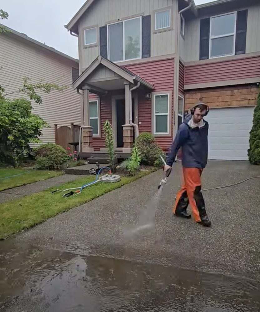 Deep Water technician pressure washing a driveway at a Seattle-area home