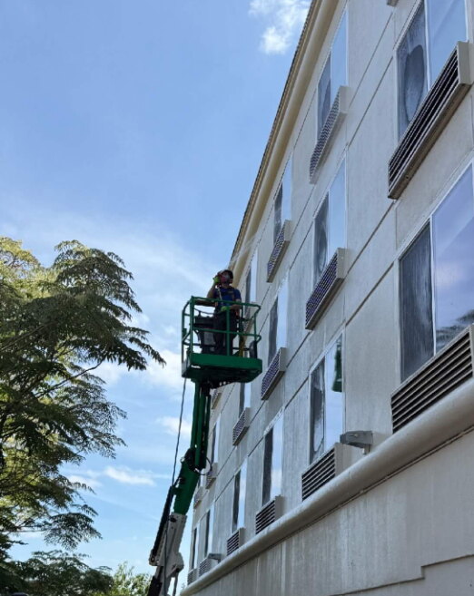 Deep Water technician washing a multi-story building from a boom lift