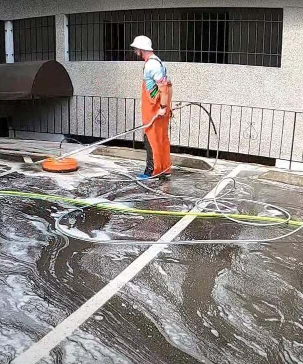 Technician surface cleaning a commercial parking court