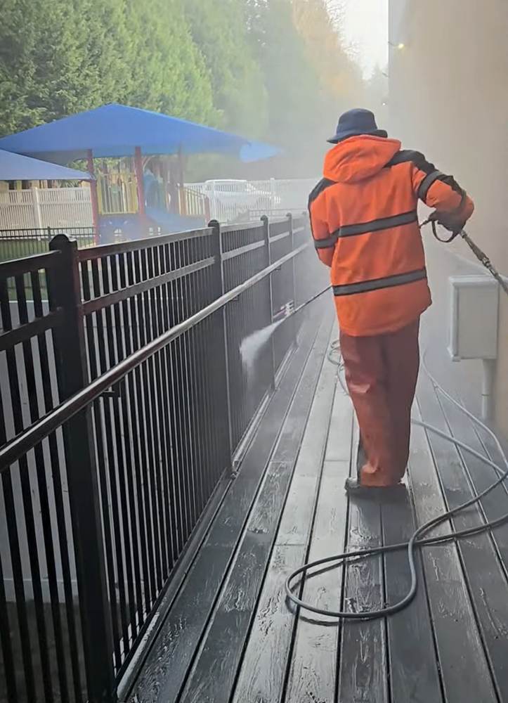 Deep Water technician pressure washing a restaurant patio walkway