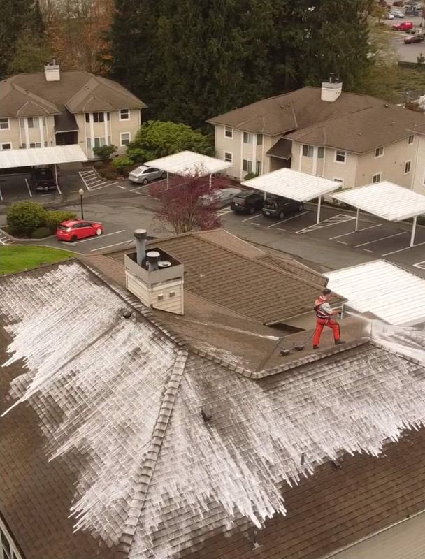 Deep Water technician soft washing the roof of an apartment community