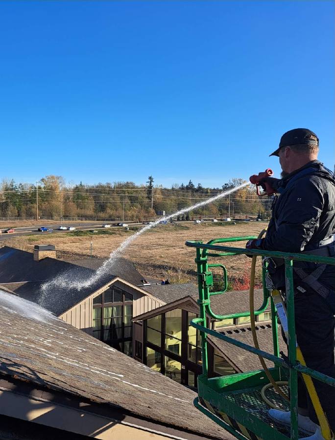 Deep Water technician soft washing a Redmond roof