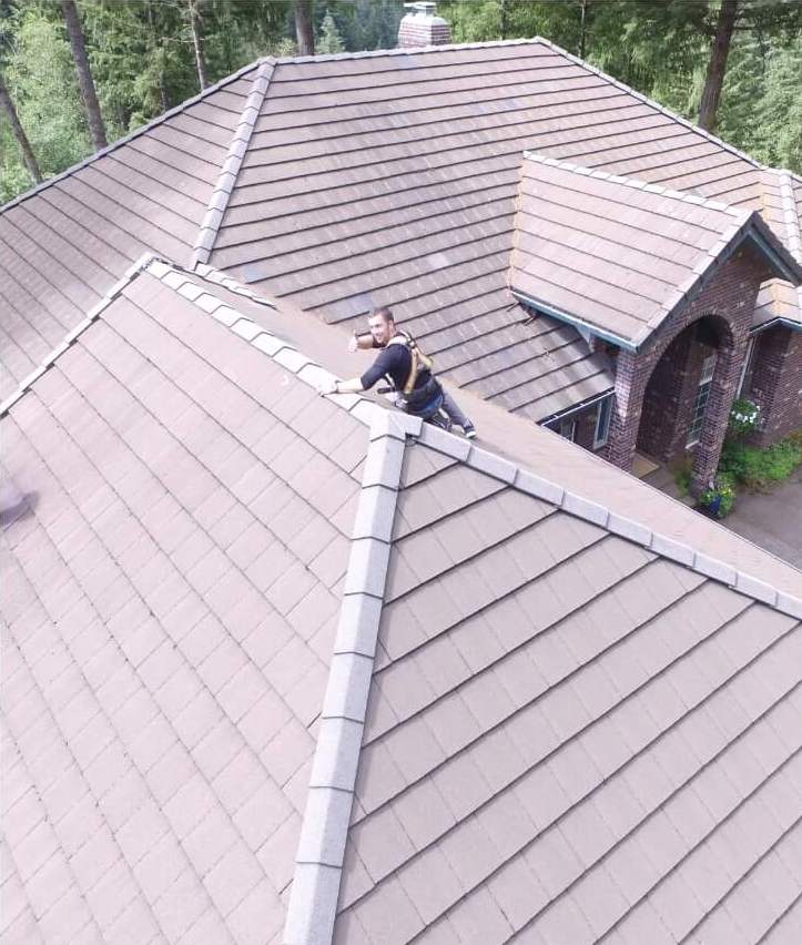 Deep Water technician soft washing a tile roof on a Bellevue home